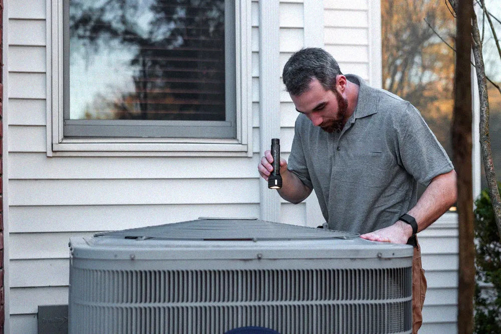 HVAC technician inspecting an outdoor AC unit refrigerant label