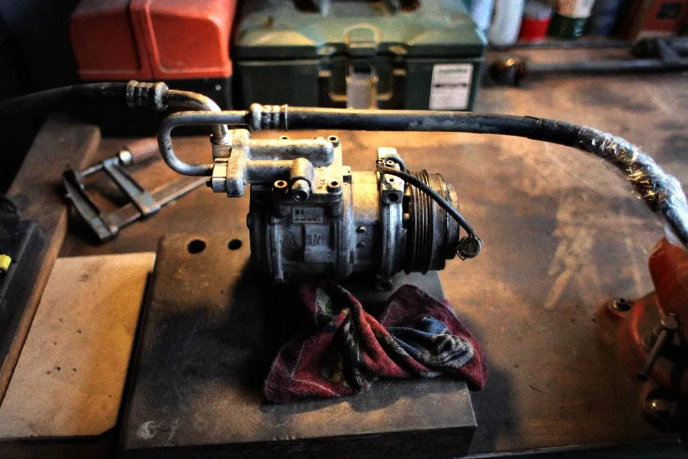 Refrigeration compressor on a workshop bench illustrating the importance of correct compressor oil