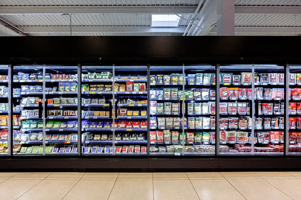 Refrigerated grocery store aisle containing commercial display cases