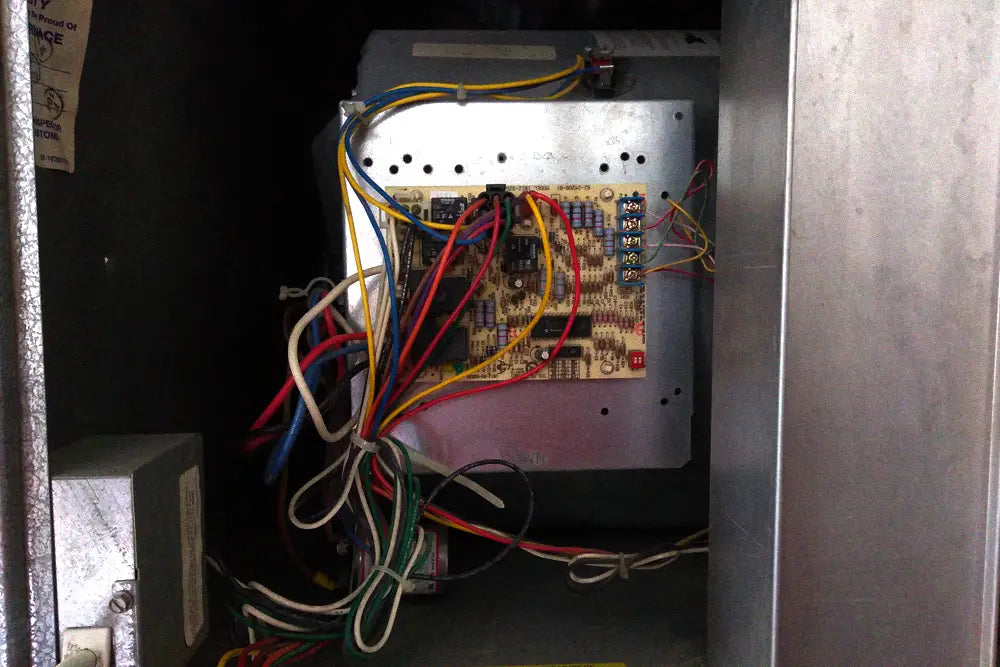 Open HVAC control compartment showing the circuit board, wiring, and service components