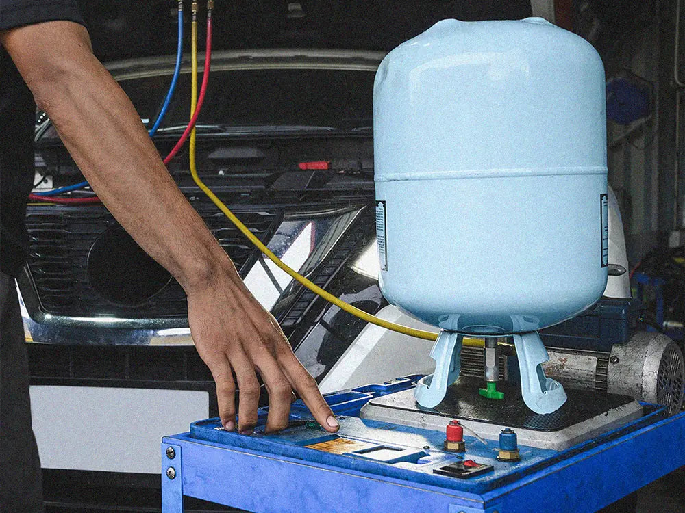 R134A refrigerant cylinder connected to automotive AC service equipment
